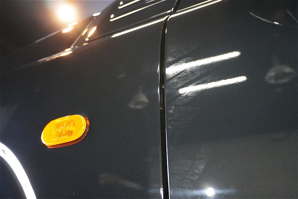 お車の施工前（Before）クローズアップ。ジムニーのフラットなパネルに固着したテープ跡のシミ。これが職人の適切な洗浄と磨きによってどう生まれ変わるかご期待ください。