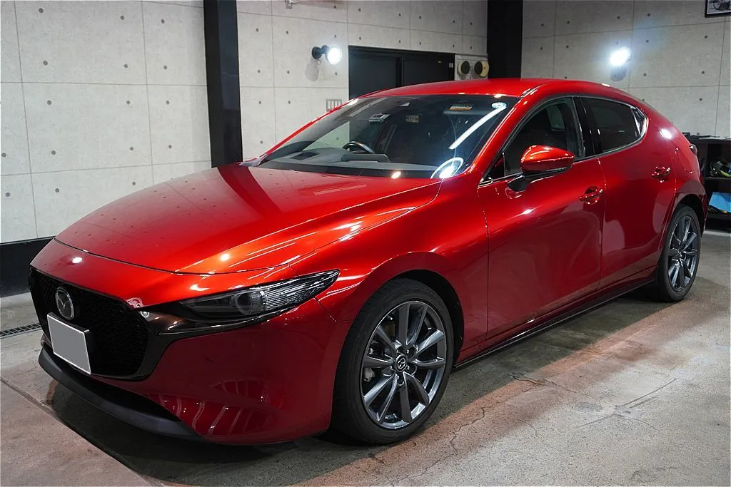 リボルト仙台によるMAZDA3施工。ガラス被膜特有の透明感が、滑らかなボディ曲面が生み出す艶やかな移ろいと陰影を優雅に際立たせます。
